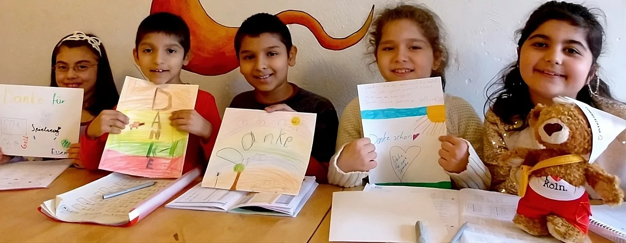 satt & schlau – Förderverein satt & schlau - Bild für die Seite "Förderverein " - Es zeigt Kinder die ein selbstgemaltes Bild zum "Danke" sagen in ihren Händen halten.